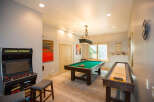 This stunning game room features a Legends Ultimate arcade game, a pool table, and a shuffleboard, offering endless entertainment options.