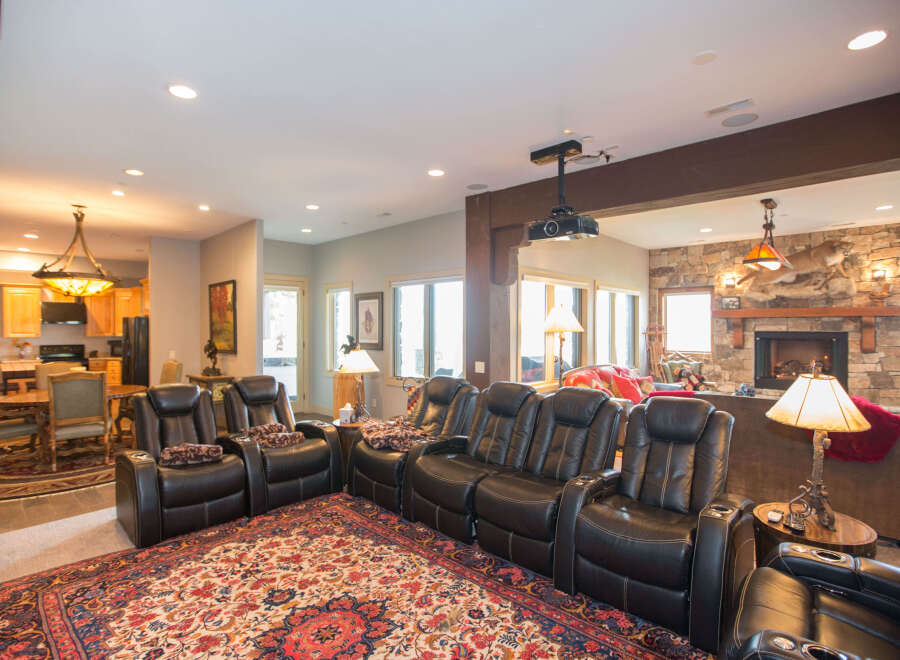 Step into luxury with this stunning home theater! Featuring plush leather recliners, a cozy fireplace, and a state-of-the-art projector, this space is perfect for movie nights.