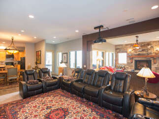 Step into luxury with this stunning home theater! Featuring plush leather recliners, a cozy fireplace, and a state-of-the-art projector, this space is perfect for movie nights.