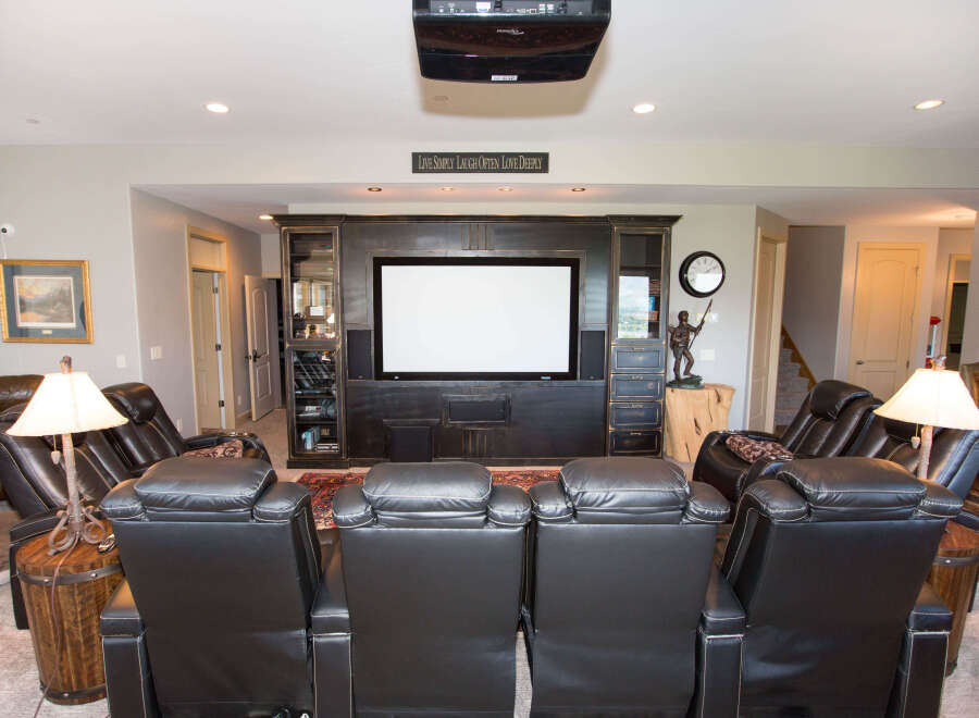 Experience luxury in this stunning home theater, complete with plush leather recliners and a state-of-the-art projector.