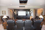 Experience luxury in this stunning home theater, complete with plush leather recliners and a state-of-the-art projector.