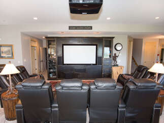 Experience luxury in this stunning home theater, complete with plush leather recliners and a state-of-the-art projector.