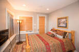 Cozy bedroom with rustic wooden bed frame and warm lighting.
