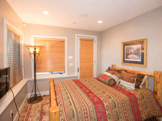 Cozy bedroom with rustic wooden bed frame and warm lighting.