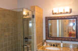 This bathroom features a stylish chandelier and a modern glass shower.