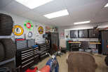 This garage is a haven for any car enthusiast, featuring a vintage motorcycle and a collection of classic signs.
