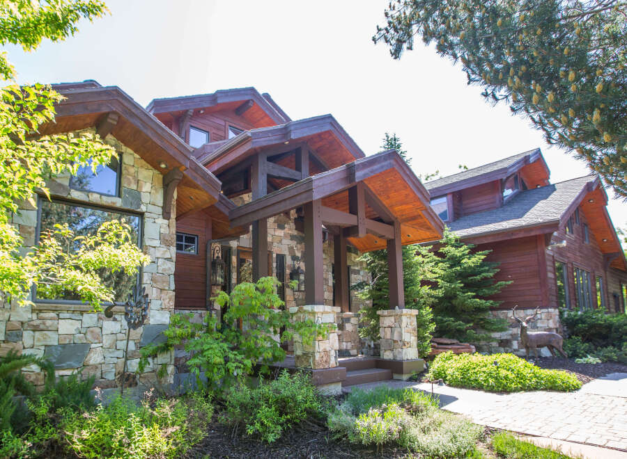 This stunning home showcases exquisite craftsmanship with its stone and wood exterior.