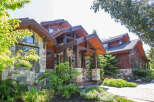 This stunning home showcases exquisite craftsmanship with its stone and wood exterior.