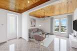 This stunning property boasts a spacious living area with large windows offering breathtaking views, complemented by a unique wooden ceiling and stylish furnishings.
