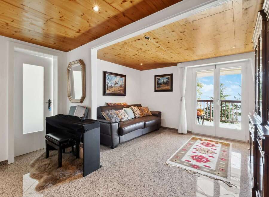 This stunning property boasts a spacious living area with a leather sofa, hardwood floors, and large windows offering breathtaking views.