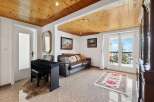 This stunning property boasts a spacious living area with a leather sofa, hardwood floors, and large windows offering breathtaking views.