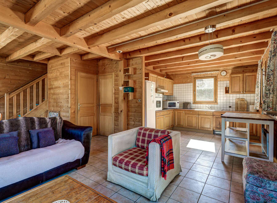 This cozy cabin boasts a warm, inviting atmosphere with its wooden interior and exposed beams.