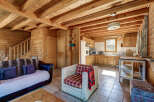 This cozy cabin boasts a warm, inviting atmosphere with its wooden interior and exposed beams.