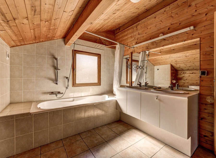 This charming bathroom features a unique wooden ceiling and walls, creating a warm and inviting atmosphere.