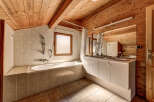 This charming bathroom features a unique wooden ceiling and walls, creating a warm and inviting atmosphere.