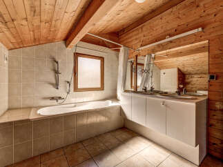 This charming bathroom features a unique wooden ceiling and walls, creating a warm and inviting atmosphere.