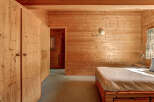 Step into a cozy bedroom retreat, featuring warm wooden paneling that envelops the space.