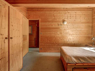 Step into a cozy bedroom retreat, featuring warm wooden paneling that envelops the space.
