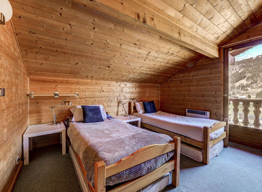 Cozy up in this charming bedroom with its warm wooden accents and inviting atmosphere.