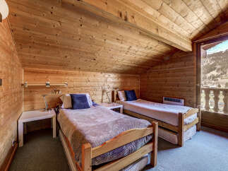 Cozy up in this charming bedroom with its warm wooden accents and inviting atmosphere.