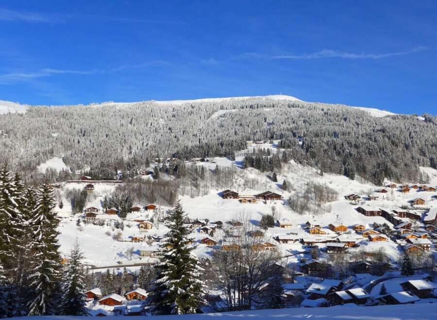 Experience the charm of a winter wonderland in this picturesque village nestled amidst snow-covered mountains.