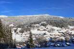 Experience the charm of a winter wonderland in this picturesque village nestled amidst snow-covered mountains.