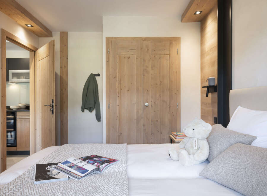 Cozy bedroom with wooden accents and a plush teddy bear.