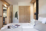 Cozy bedroom with wooden accents and a plush teddy bear.