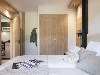 Cozy bedroom with wooden accents and a plush teddy bear.