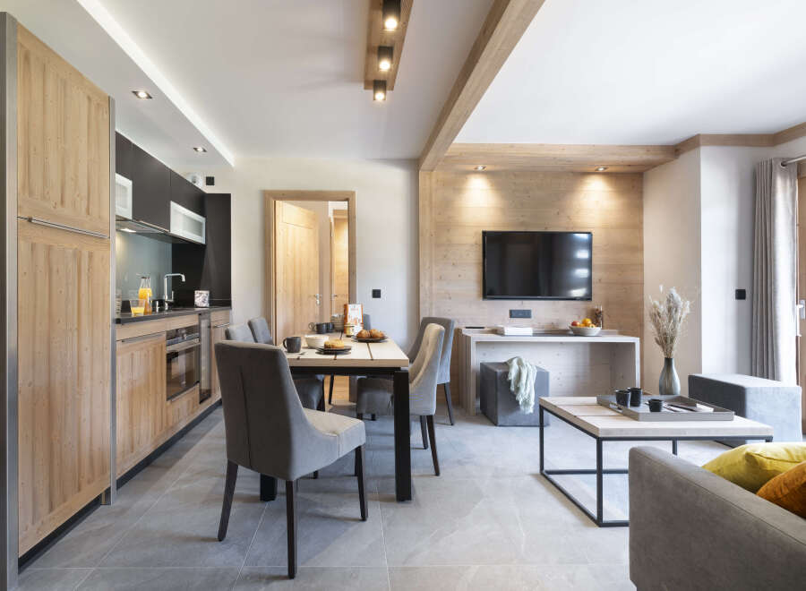 This stunning apartment boasts an open-plan living area with a modern kitchen, dining table, and comfortable seating.