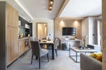 This stunning apartment boasts an open-plan living area with a modern kitchen, dining table, and comfortable seating.
