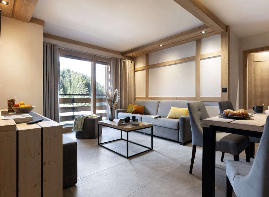 This stunning apartment boasts a spacious open-plan living area with floor-to-ceiling windows offering breathtaking views of the surrounding forest.