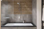 Modern bathroom with a sleek, built-in bathtub and a walk-in shower featuring a rainfall shower head.