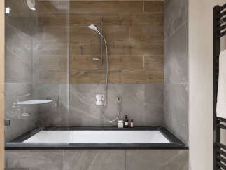 Modern bathroom with a sleek, built-in bathtub and a walk-in shower featuring a rainfall shower head.