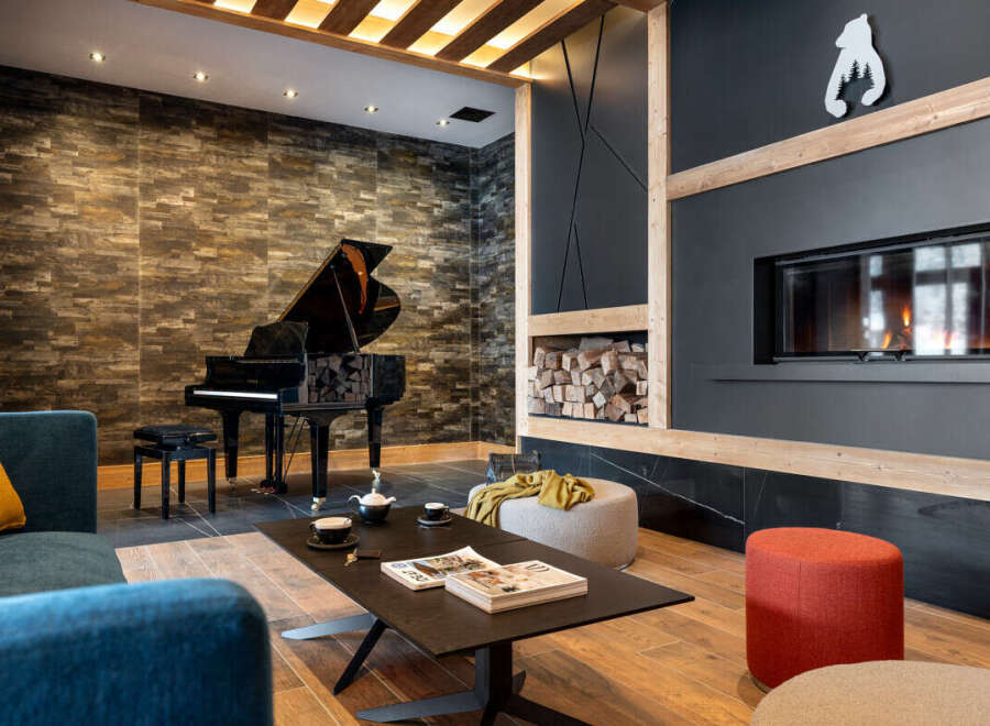 This stunning property boasts a spacious living area with a grand piano, a cozy fireplace, and comfortable seating, perfect for relaxing evenings.