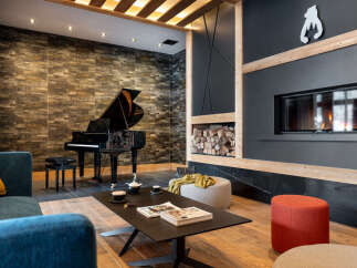 This stunning property boasts a spacious living area with a grand piano, a cozy fireplace, and comfortable seating, perfect for relaxing evenings.