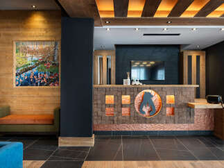 This hotel boasts a stunning reception area with a unique copper and wood design, featuring a backlit bear logo.