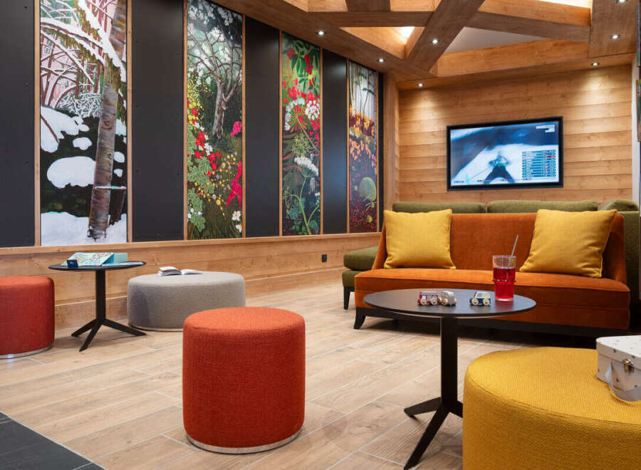Relax in style in this cozy lounge area, featuring comfortable seating, a large screen TV, and unique nature-inspired wall art.