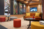 Relax in style in this cozy lounge area, featuring comfortable seating, a large screen TV, and unique nature-inspired wall art.