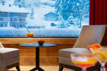 Cozy lounge area with stunning views of a snow-covered mountain village.