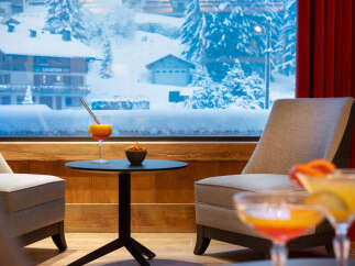 Cozy lounge area with stunning views of a snow-covered mountain village.