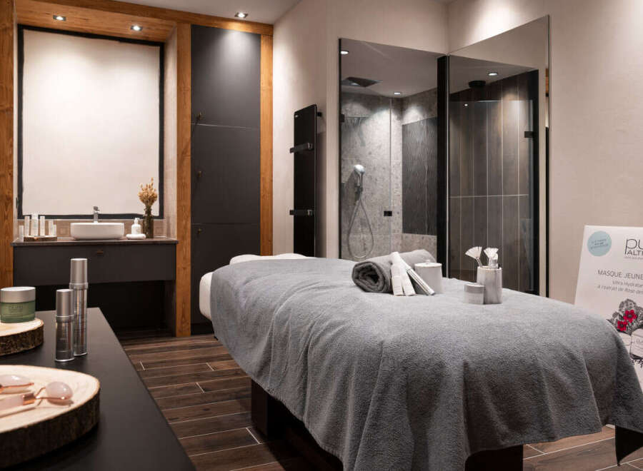 Indulge in pure relaxation at our luxurious spa, featuring a serene massage room complete with plush linens and premium skincare products.