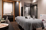 Indulge in pure relaxation at our luxurious spa, featuring a serene massage room complete with plush linens and premium skincare products.