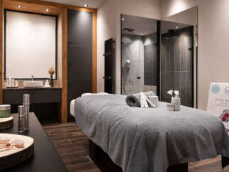 Indulge in pure relaxation at our luxurious spa, featuring a serene massage room complete with plush linens and premium skincare products.