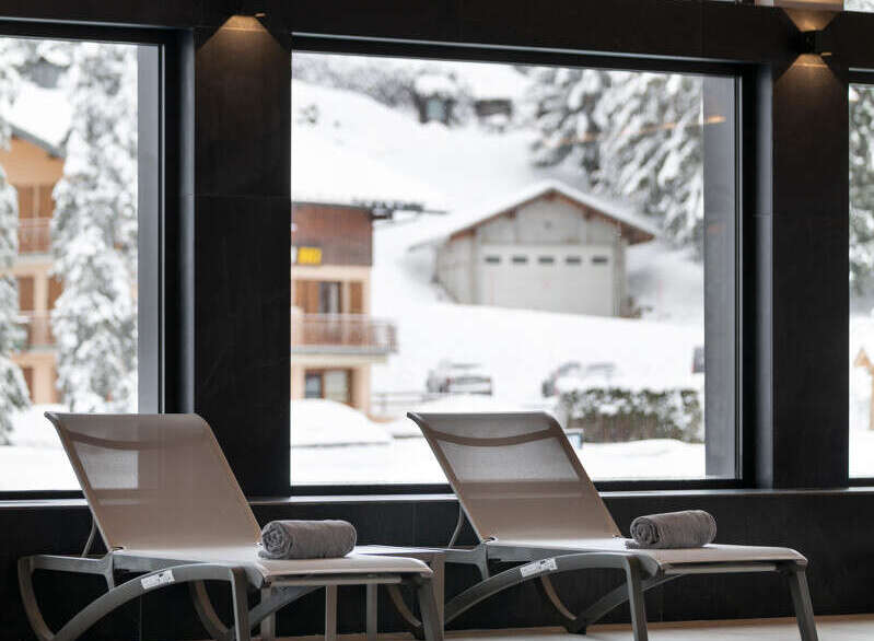 Luxury hotel pool with stunning views of a snow-covered mountain landscape.