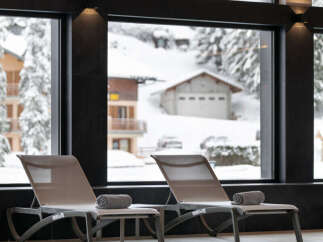 Luxury hotel pool with stunning views of a snow-covered mountain landscape.