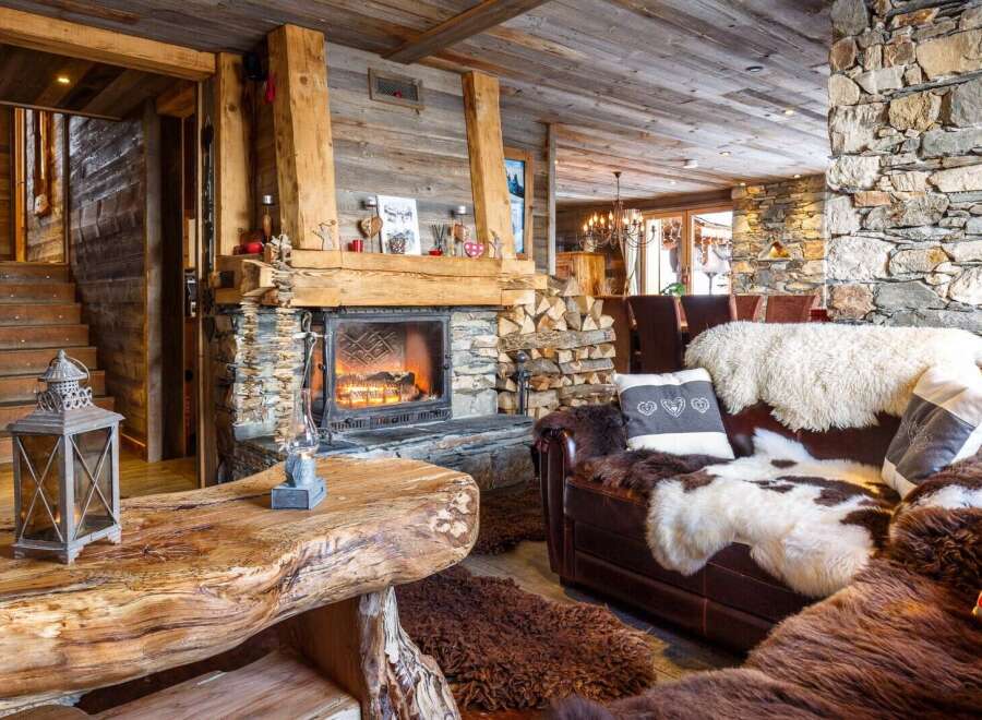 Cozy up by the fireplace in this stunning chalet, featuring rustic wood and stone finishes.