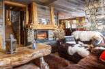 Cozy up by the fireplace in this stunning chalet, featuring rustic wood and stone finishes.