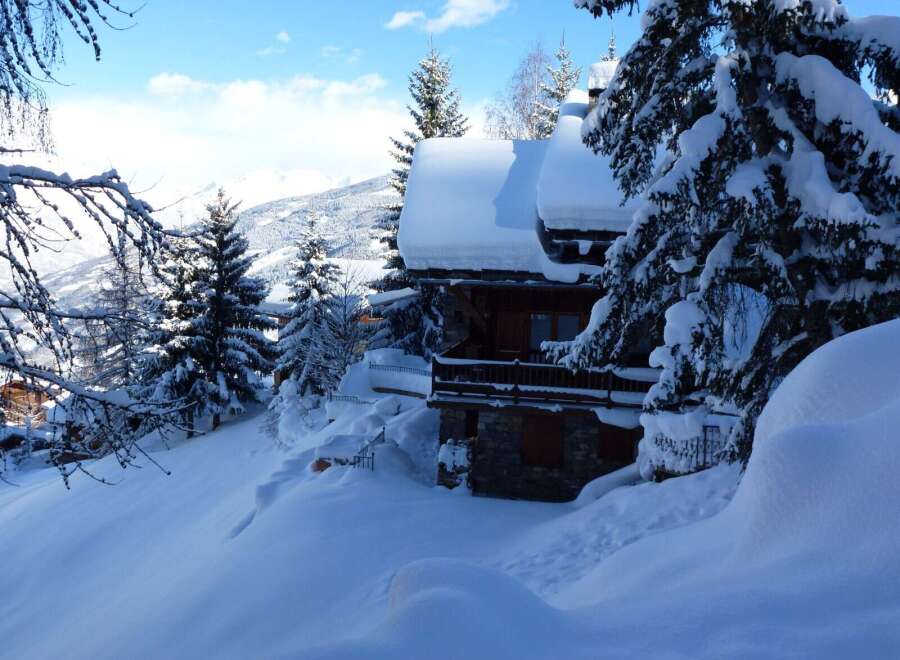 This stunning chalet boasts breathtaking mountain views and is nestled in a picturesque snow-covered landscape.