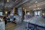 This stunning chalet boasts a spacious open-plan living area with a rustic wooden dining table perfect for large gatherings.